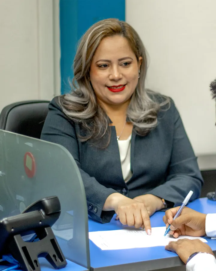 Asesora conversando con un cliente PYME mientras firma un documento