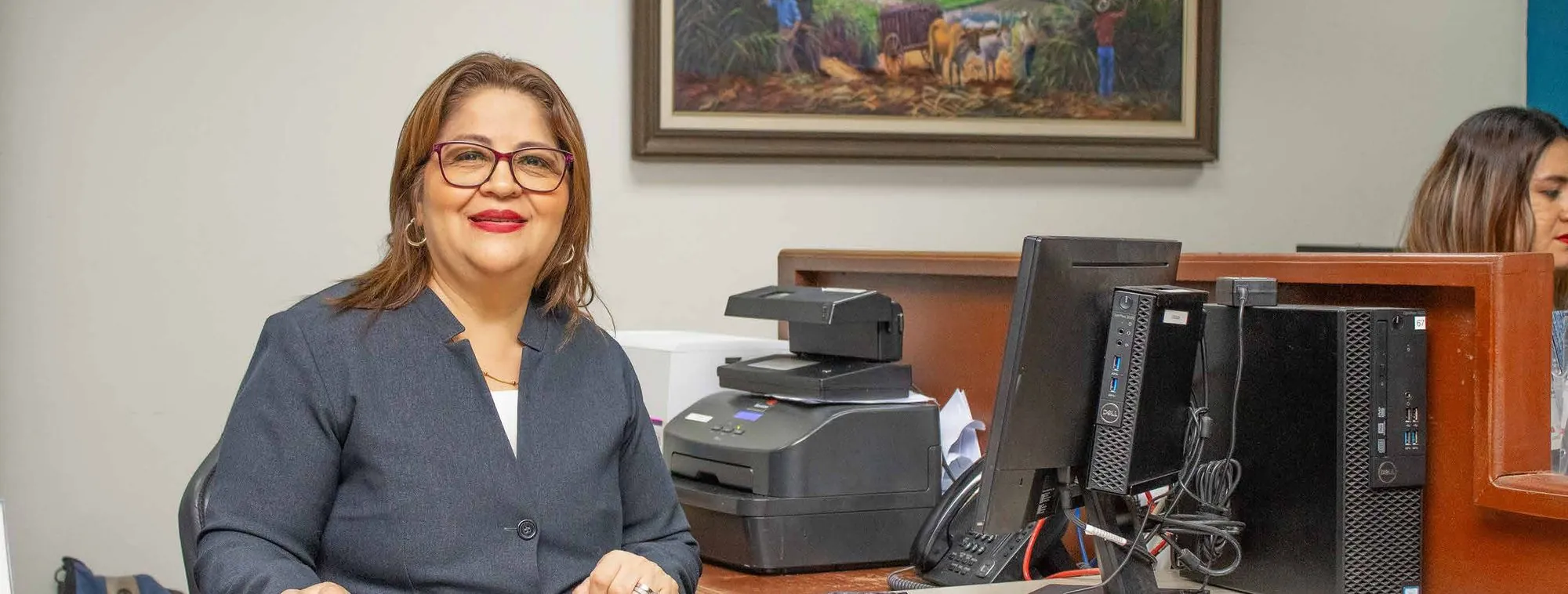 Asesora de Banco Izalqueño sonriendo en su escritorio